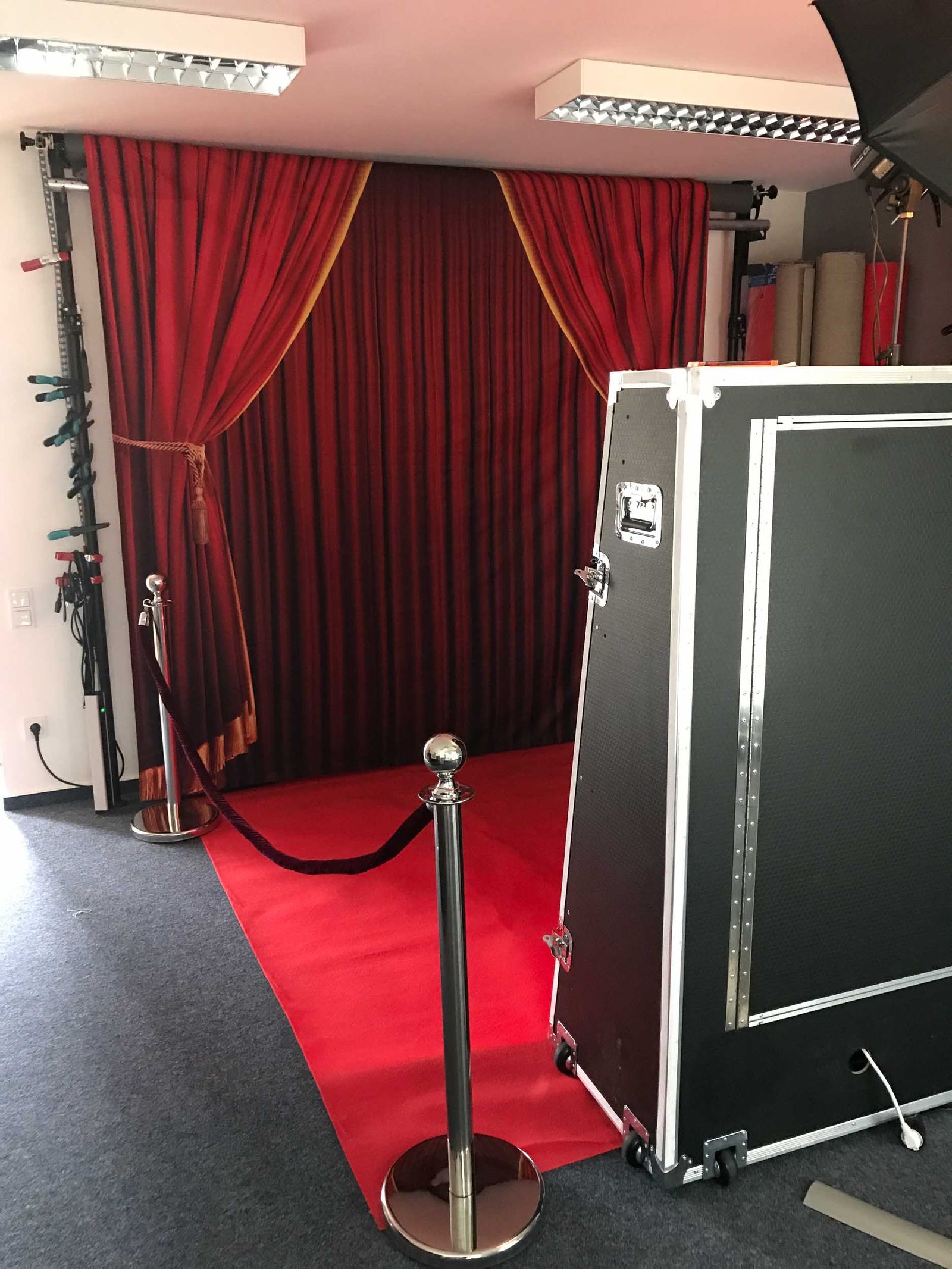 Magic Mirror Setup bei Foto Lutz — 1,90 m Spiegel-Fotobox in Transportkiste vor rotem Theatervorhang als Test-Backdrop, mit Absperrsystem und rotem Teppich