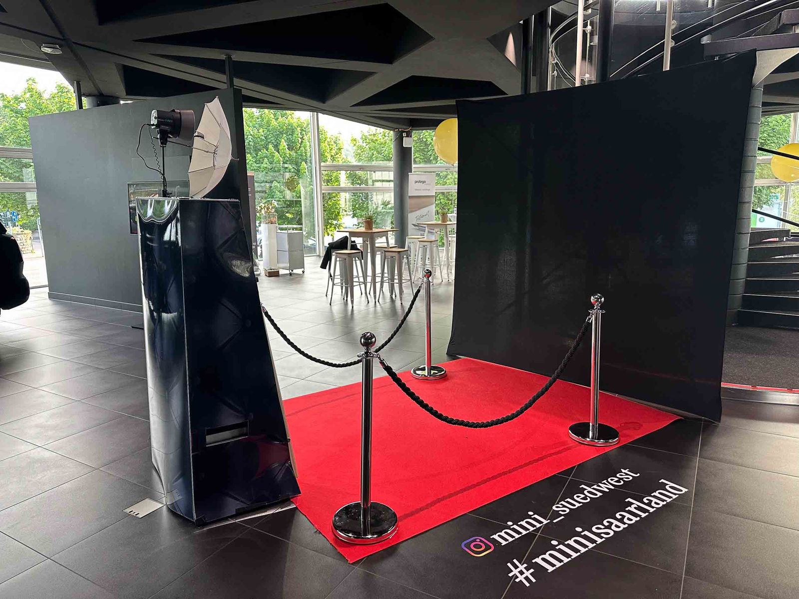Magic Mirror Setup bei MINI Südwest Saarland — schwarze Box mit Studio-Reflektor, schwarzer Backdrop, roter Teppich mit @mini_suedwest und #minisaarland Hashtag-Branding