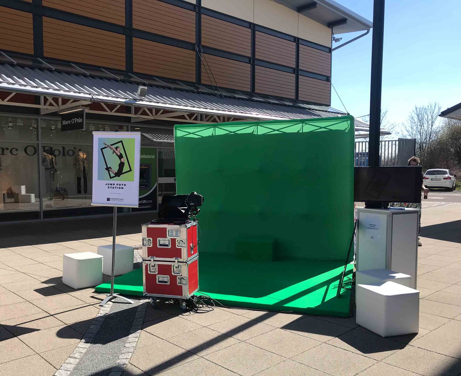 Foto Lutz Greenscreen-Setup mit Fotoprintmodul im Fashion Outlet Zweibrücken — Greenscreen-Wand, JUMP FOTO STATION Roll-up, Marc O'Polo Store im Hintergrund
